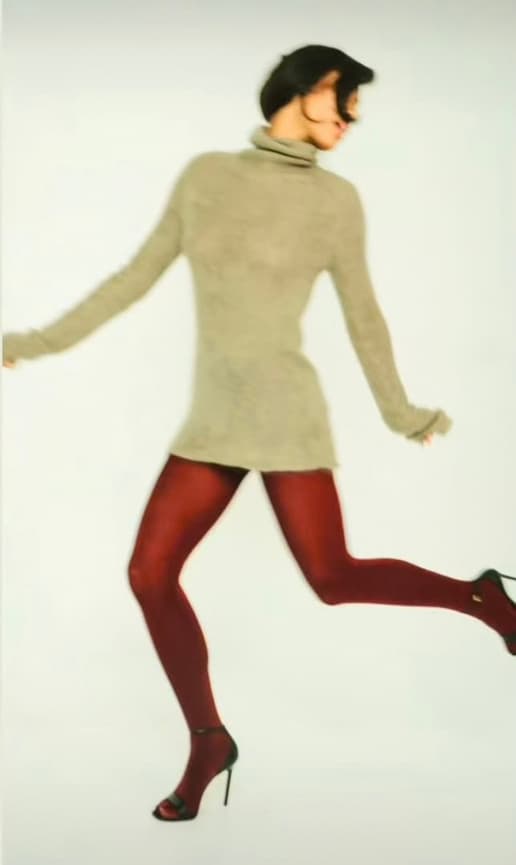 Mischief Maison Studio target customer in a grey turtleneck sweater dress and burgundy tights, effortless and timeless